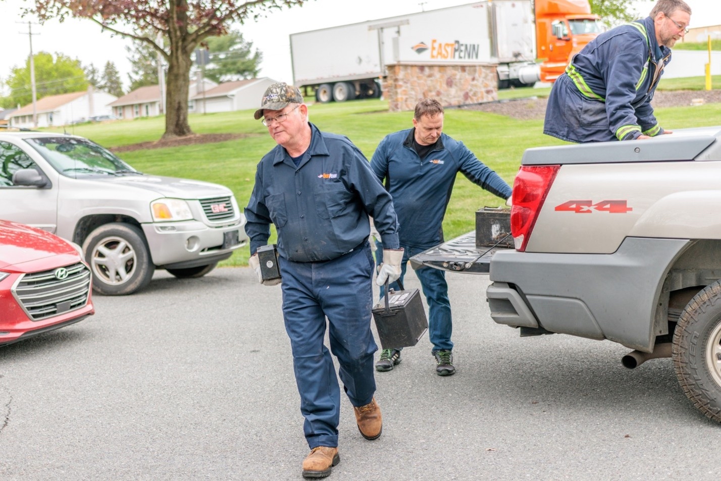 Jesse Reed (front), a material handler at East Penn’s recycling facility, and Joel Brady (back), VP of marketing and communications at East Penn, unload batteries from one of the vehicles at the company’s Power2Recycle event